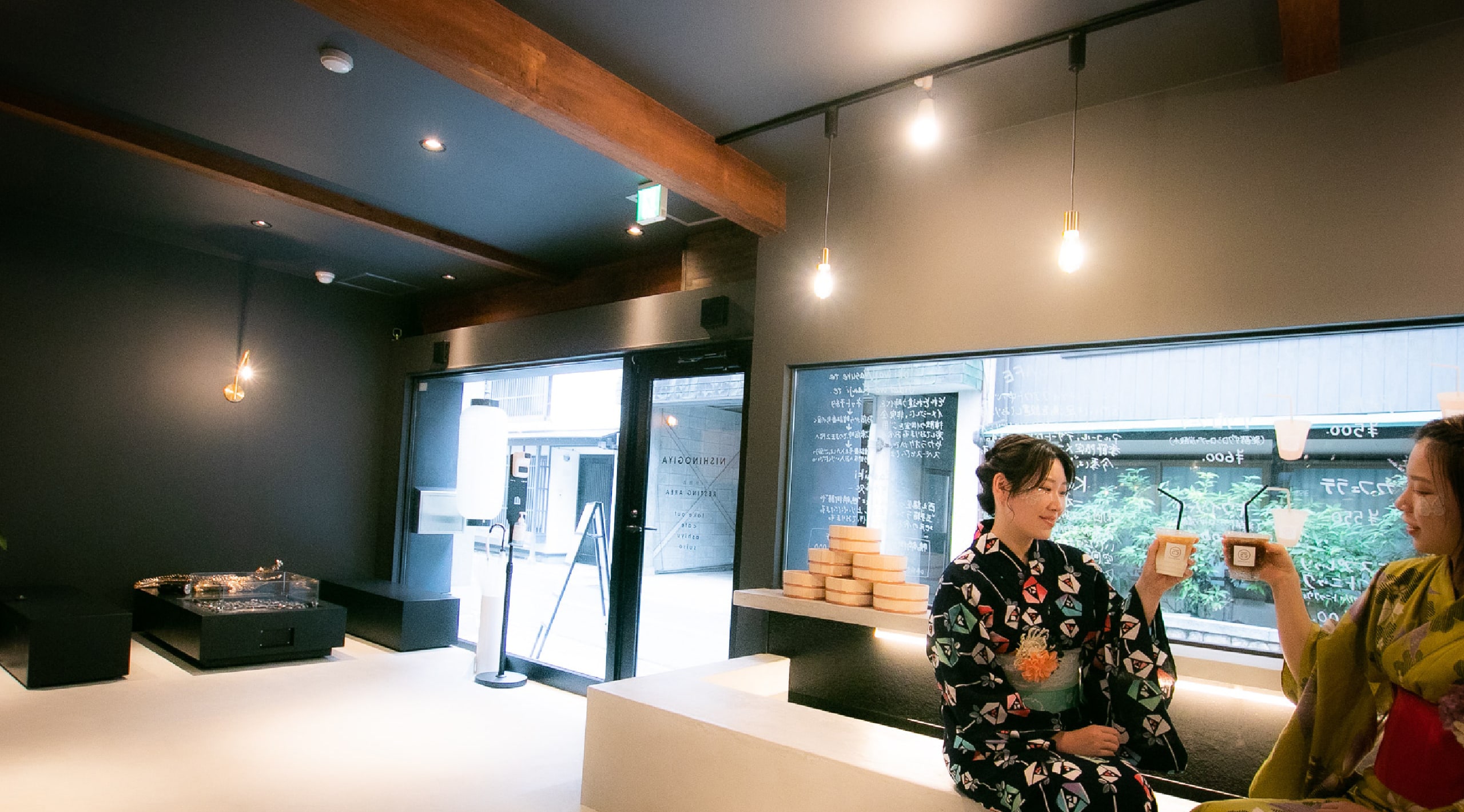 足湯カフェでドリンクを手にしている浴衣を着た二人の女性